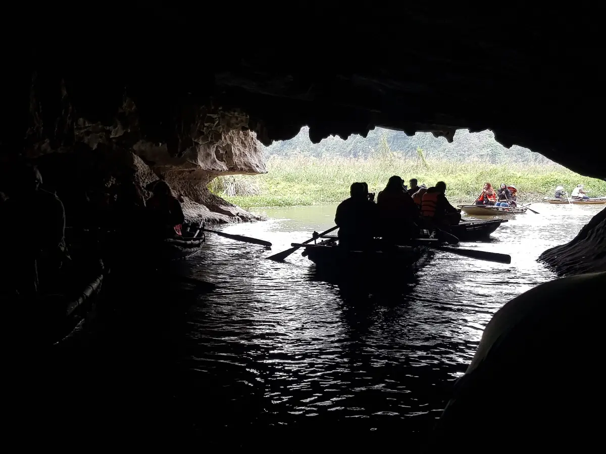 Rowing boat gliding out of a dark cave into daylight