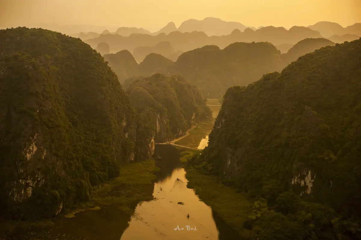 Golden light over a river valley between steep karst slopes