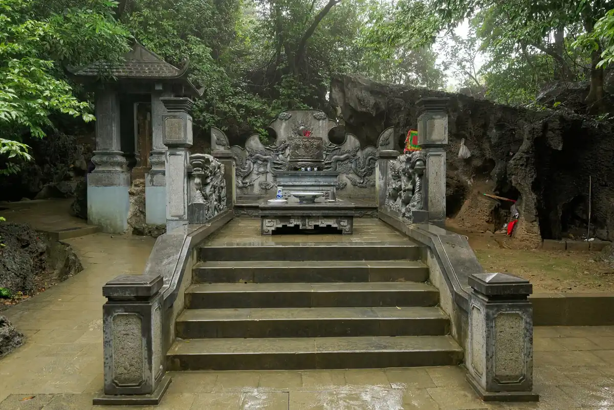 Stone steps leading up to an old shrine in a rock niche