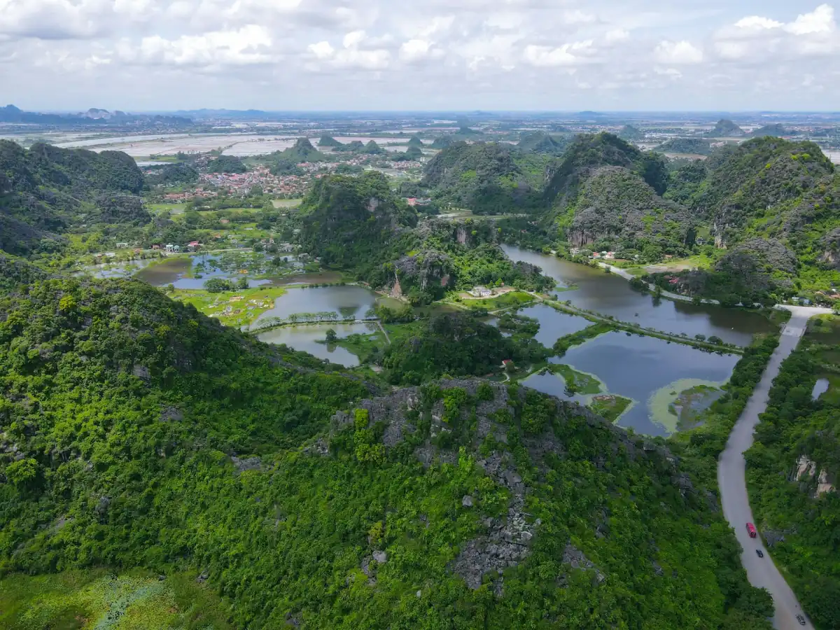 Aerial view of karst hills, flooded rice paddies and a winding road