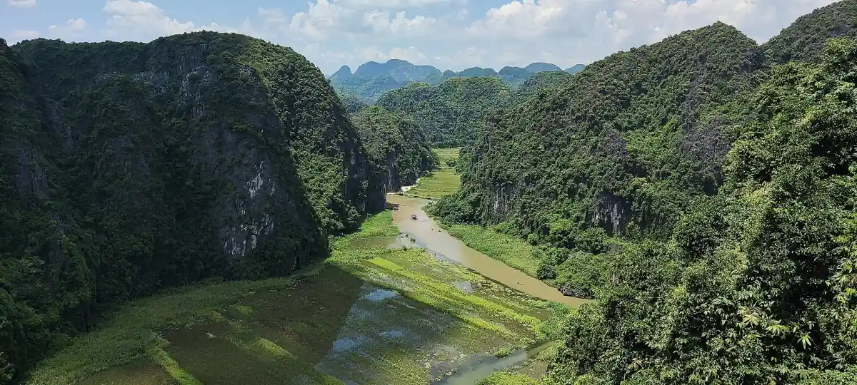 River valley between green karst hills seen from above
