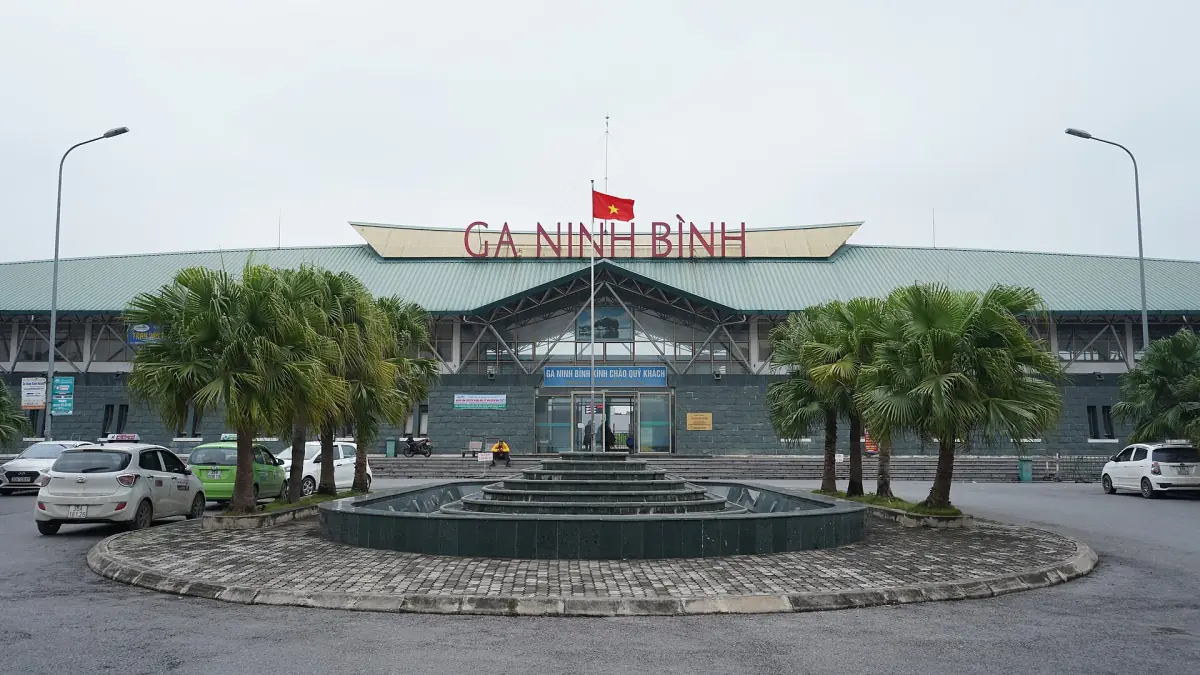 Ninh Binh railway station building with palms and a fountain